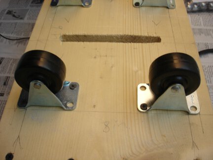 A close-up of the caster wheels and belt slot.