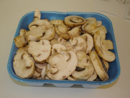 A tub of sliced white mushrooms.
