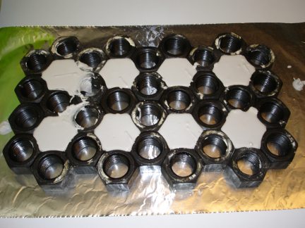 The hex nut molds filled with plaster.