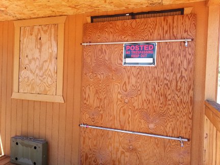 A close-up view of the boarded up front of the cabin.