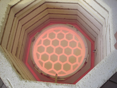 A red-hot mirror being cast in a kiln.